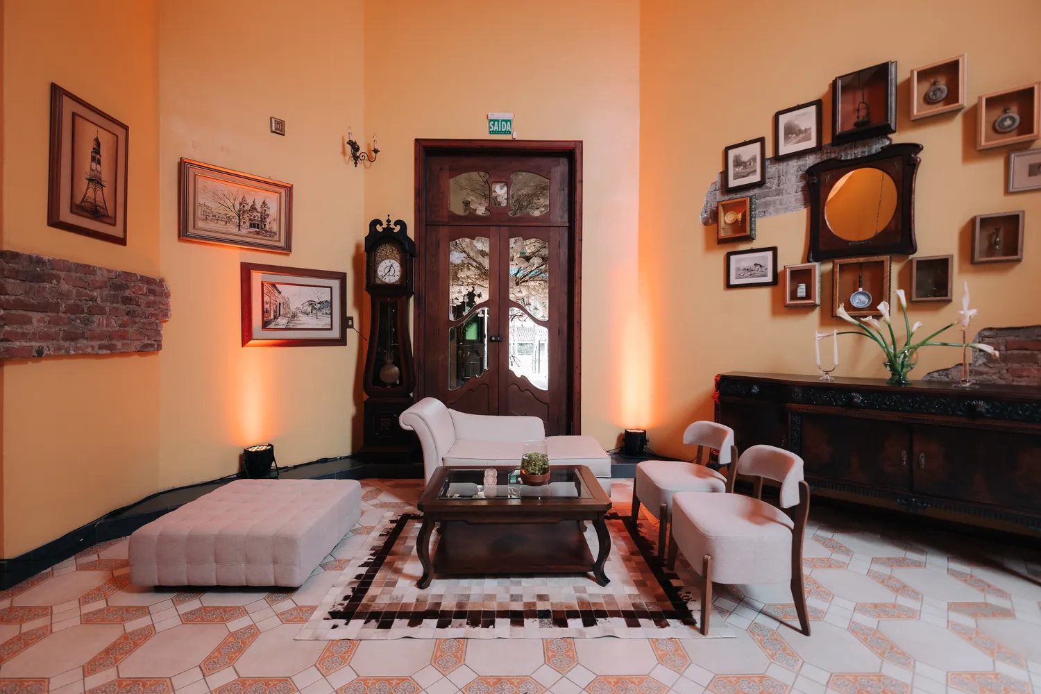 Sala de estar com sofás brancos, quadros e relógio antigo
