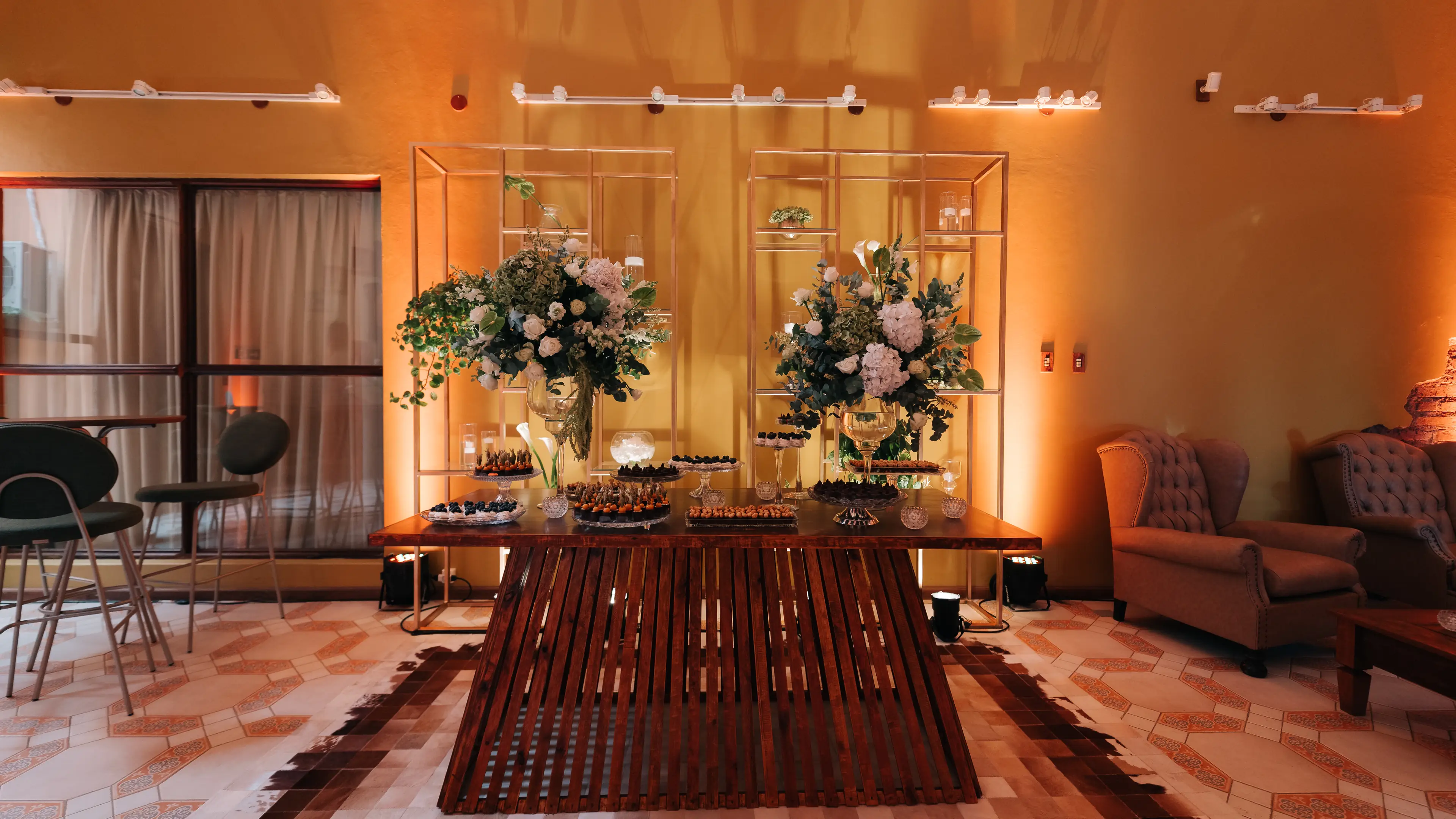 Mesa de doces com arranjos de flores brancas no salão
